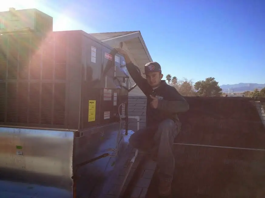 HVAC technician performing Boiler Repair on a rooftop unit in Paradise